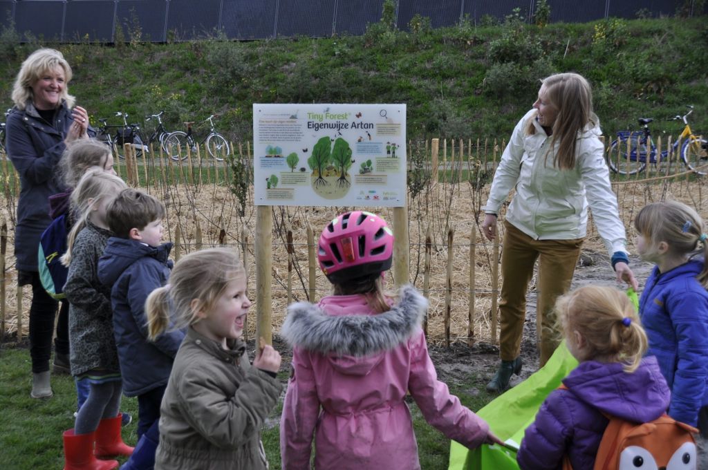 Wethouder gemeente Utrecht, Lot van Hooijdonk, opent Tiny Forest in Hoograven in Utrecht met kinderen